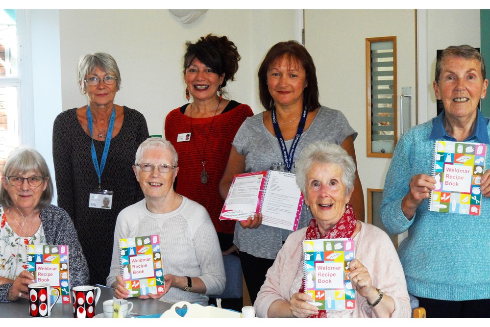Weldmar staff, volunteers and day services patients with the recipe book