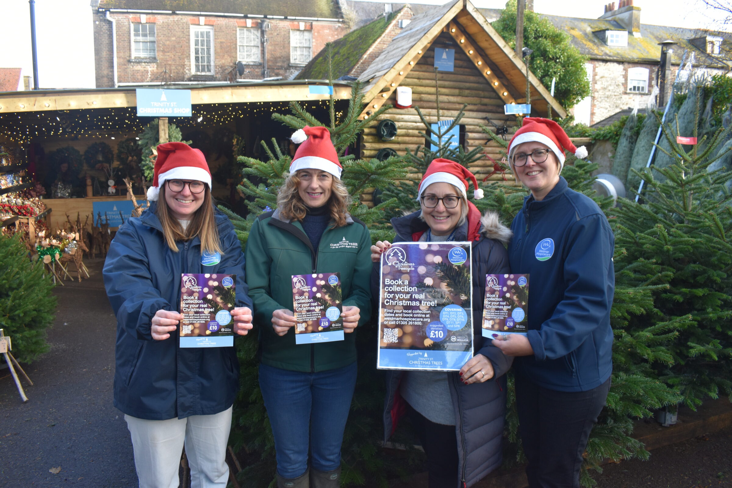 Weldmar’s Christmas Treecycle staff holding poster