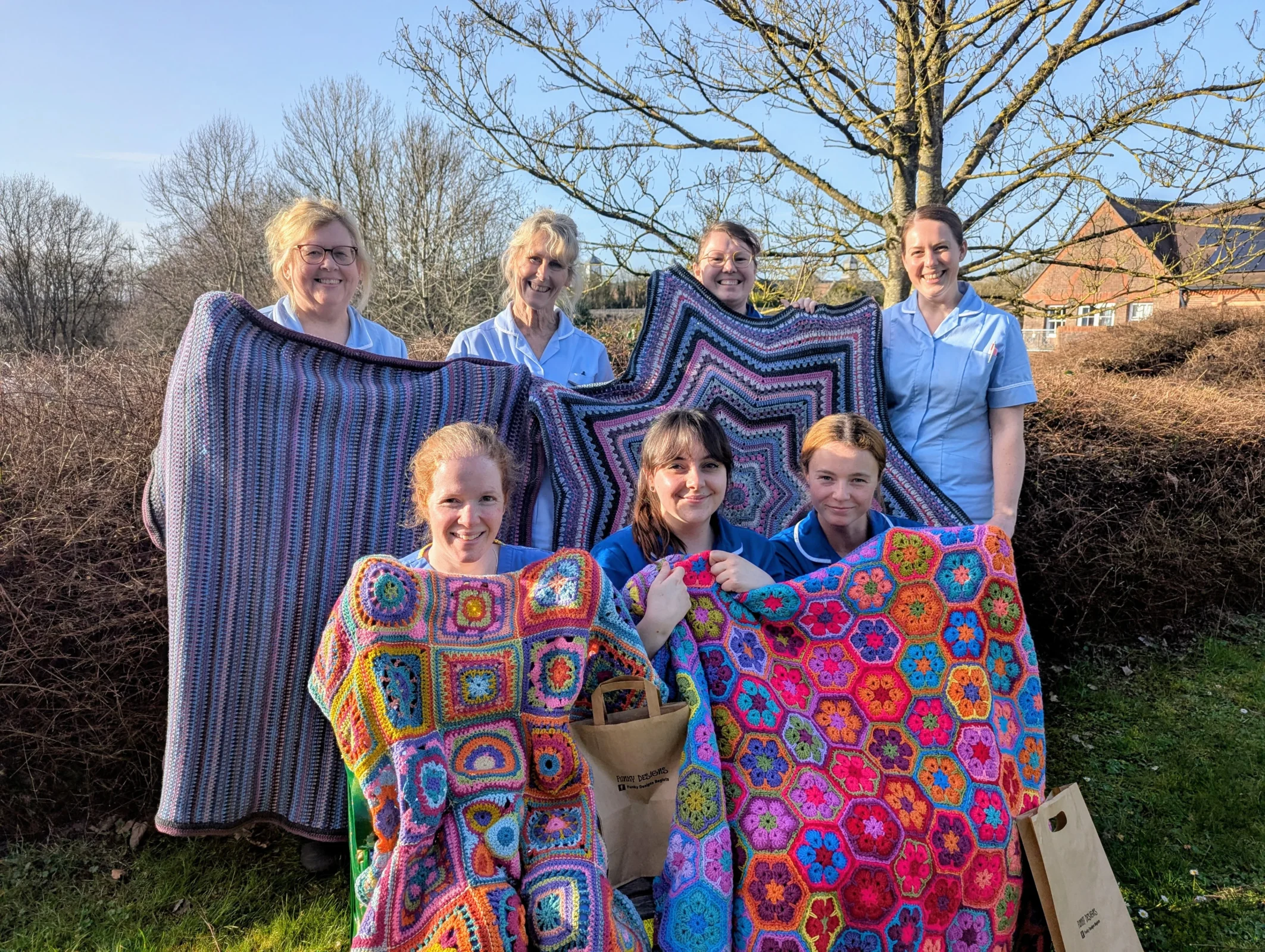 A group of Weldmar nurses holding colourful blankets