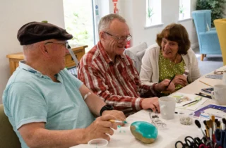 A group of people sat taking part in a crafting wellbeing session.